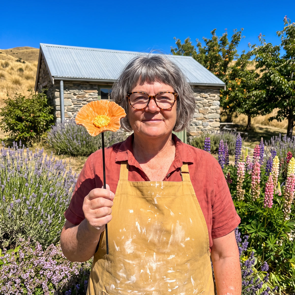 Jocelyn Joss Galloway holding a bee blossom in her garden