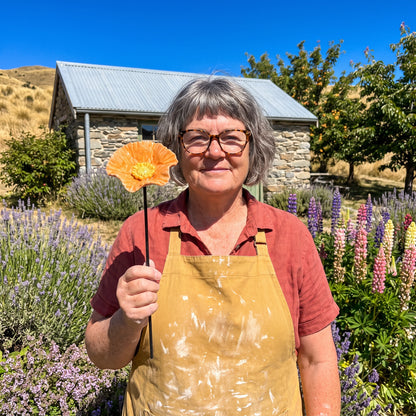 Jocelyn Joss Galloway holding a bee blossom in her garden