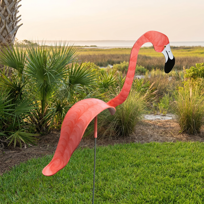 Coral pink hand-painted flamingo wind-spinner in coastal grass