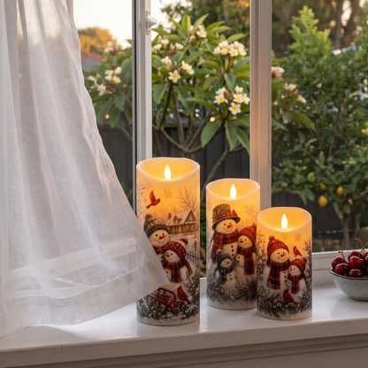 A curtain blowing against the flameless snowman candles on an open windowsill