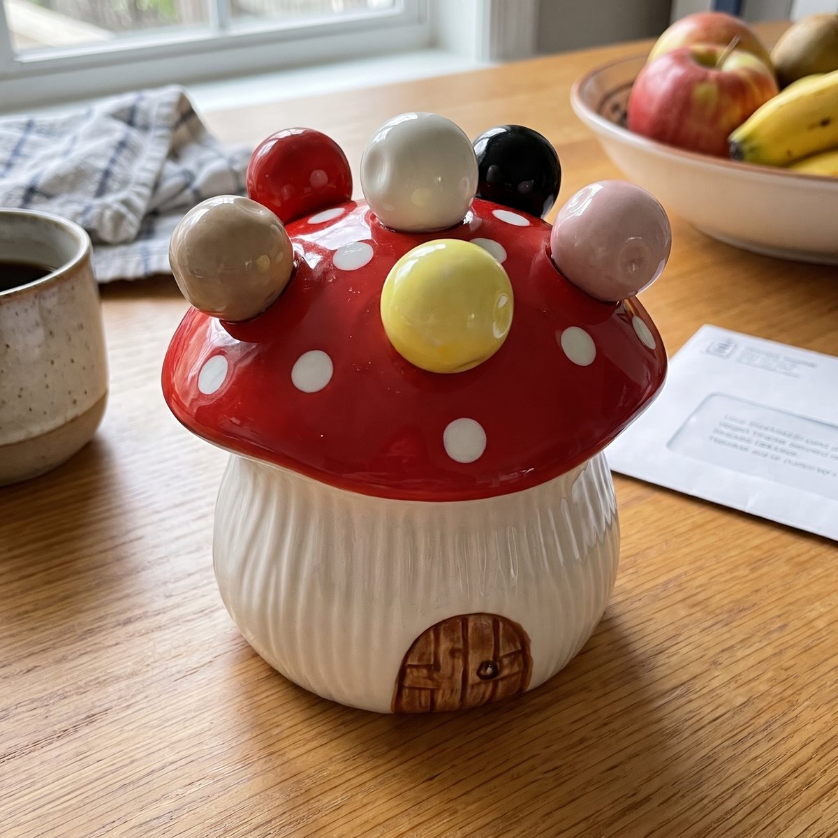 Close-up of the red cap with six colored bead handles and the little painted door