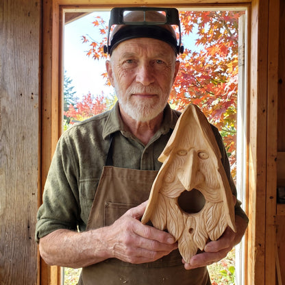 Neil Tackaberry holding one of his last carved birdhouses