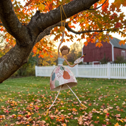 The Painter wind dancer hanging from a maple branch in a New England backyard in fall